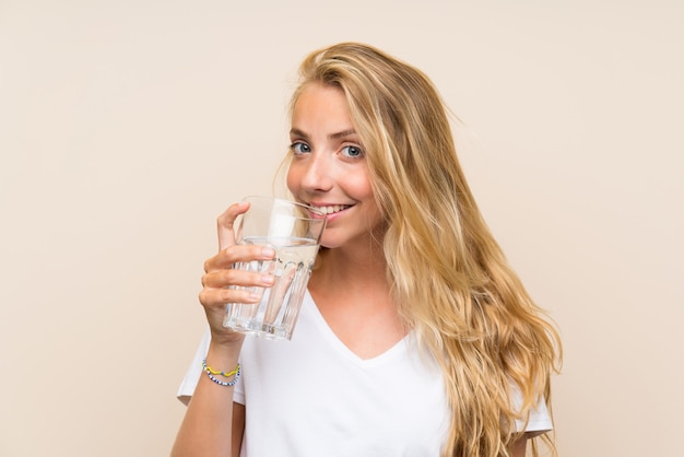 Feliz jovem mulher loira com um copo de água