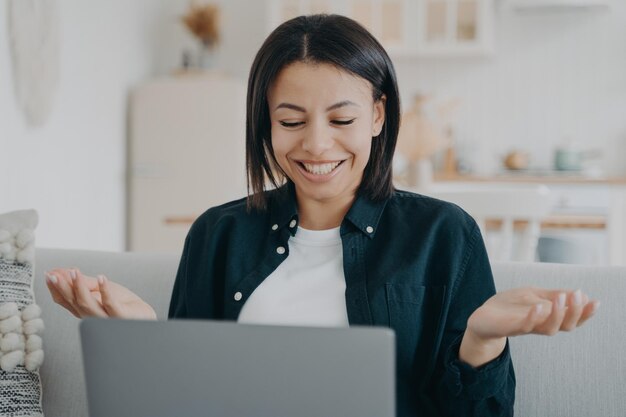 Feliz jovem mulher trabalhando no laptop surpreendida por incríveis boas notícias lendo e-mail em casa