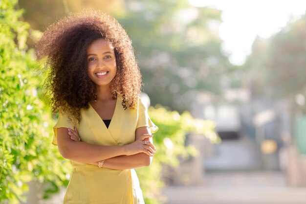 Feliz jovem negra afro tem um sorriso confiante está posando com seu cabelo encaracolado O espaço de cópia inclui