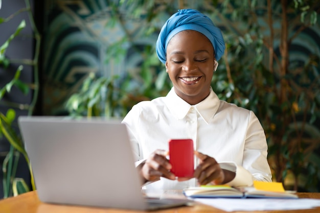 Feliz jovem negra gerenciando várias tarefas no interior do café