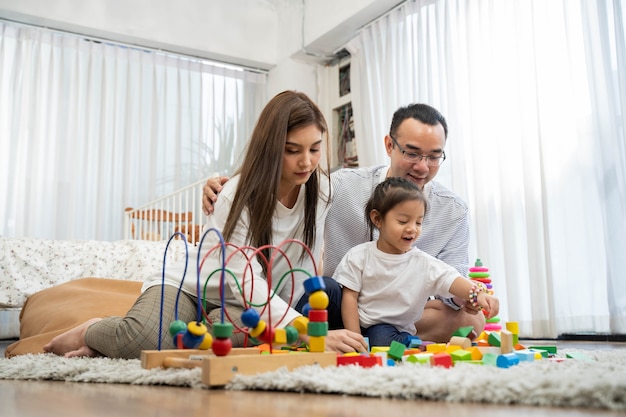 Feliz jovem pai e mãe e uma filha brincando