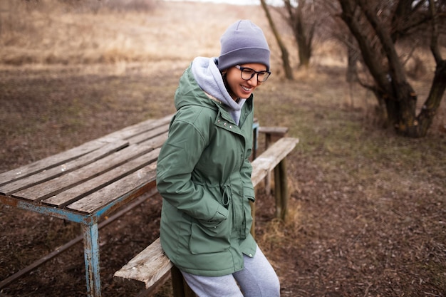 Feliz jovem sentada na cadeira ao ar livre abandonada