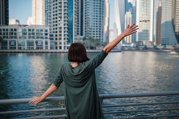 Feliz jovem viajante na grande cidade de dubai emirados árabes unidos