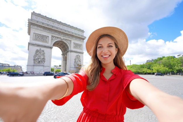 Feliz jovem viajante tirando foto selfie com Arc de Triomphe em Paris França