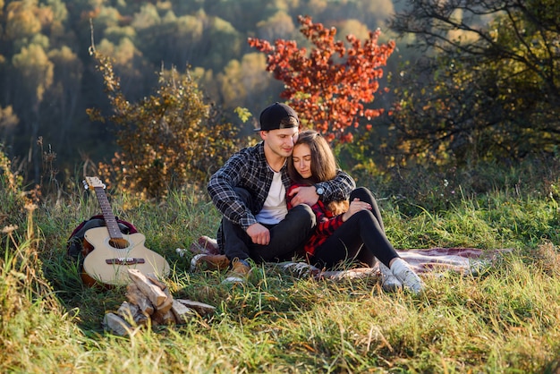 Feliz joven abraza a su novia en el picnic en el parque.