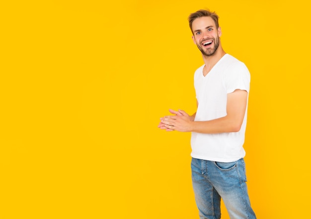 Feliz joven sin afeitar en camisa blanca sobre fondo amarillo con espacio de copia de moda