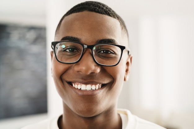 Feliz joven africano mirando a cámara en interiores en casa - Centrarse en la cara