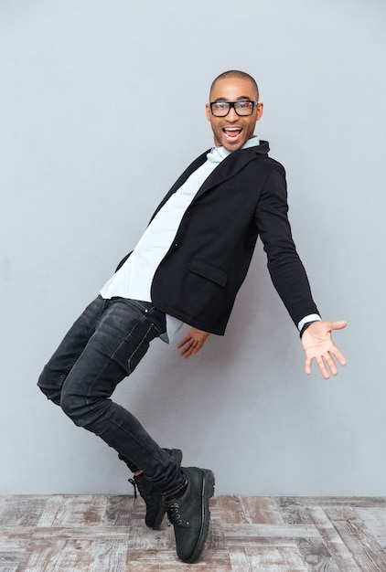 Feliz joven africano en vasos bailando y sonriendo