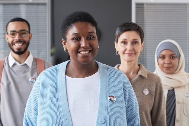 Feliz joven afroamericana con una pequeña insignia de voto redonda en el pecho