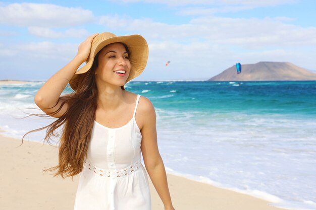 Foto feliz joven alegre con la playa de corralejo dunas en fuerteventura