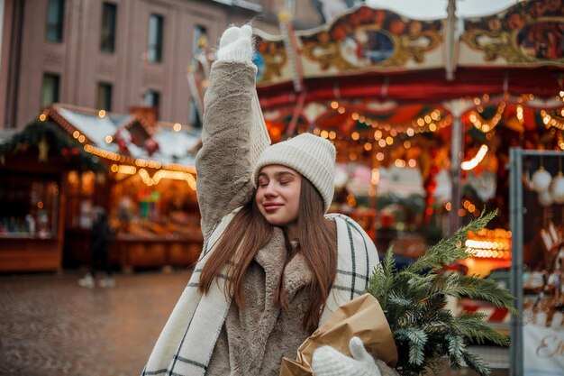 Foto feliz joven de apariencia europea en el mercado de navidad en alemania decoración festiva de la ciudad año nuevo vacaciones de invierno