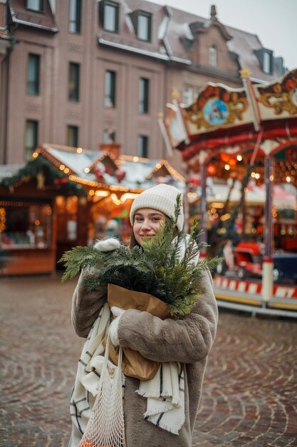 Foto feliz joven de apariencia europea en el mercado de navidad en alemania decoración festiva de la ciudad año nuevo vacaciones de invierno