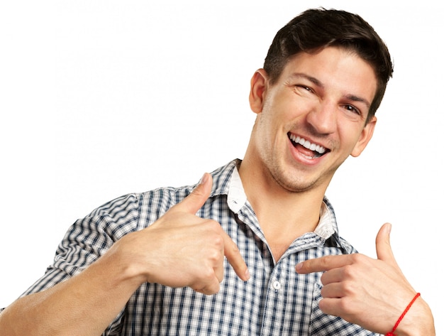 Feliz joven apuesto hombre ganador de pie contra el fondo blanco.