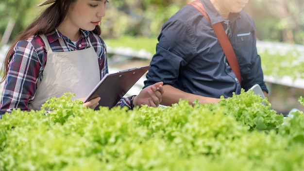 Feliz de joven asiática en la granja de vegetales