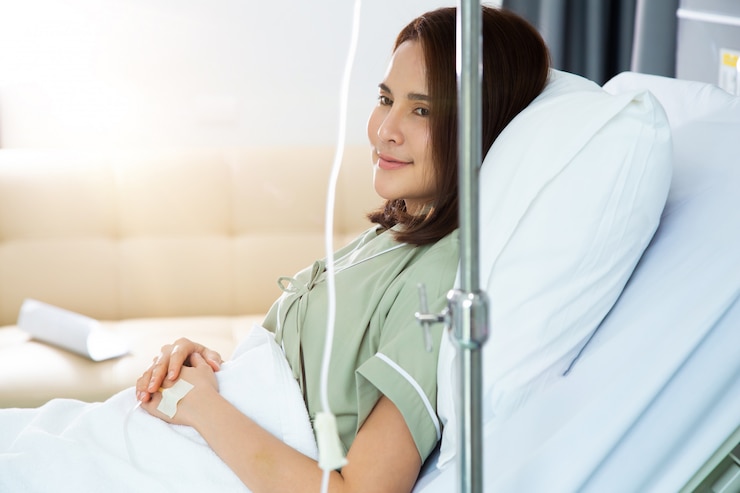 Feliz joven asiática paciente descansando en la cama del hospital y sonrisa
