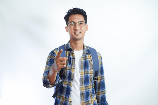 Feliz joven asiático estudiante en ropa casual bolsa gafas señalando con el dedo a la cámara en usted