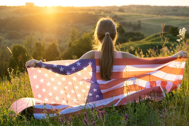 Feliz joven con la bandera nacional de los Estados Unidos en la mano