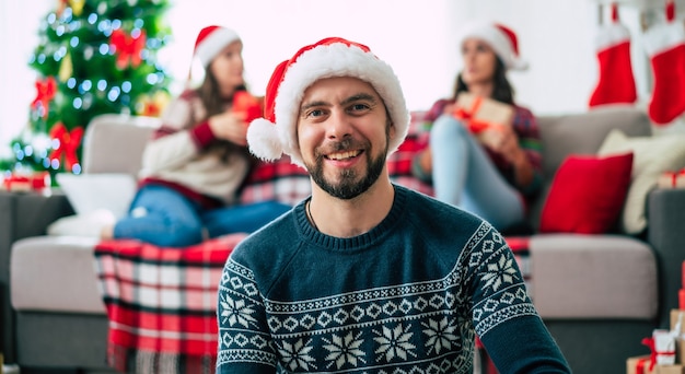 Feliz joven barbudo con un gorro de Papá Noel de Navidad