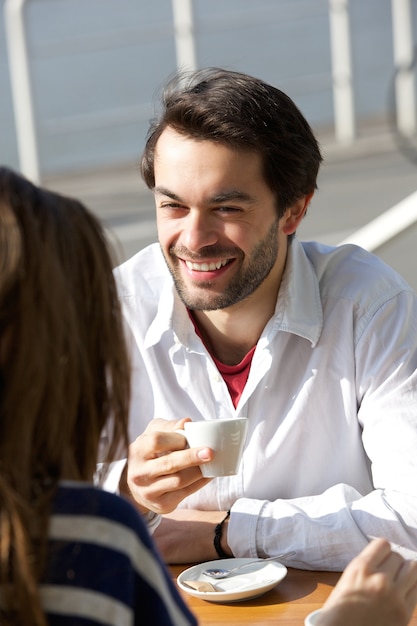 Feliz joven bebiendo café con mujer