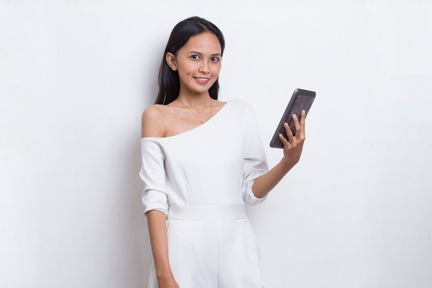 Feliz joven bella mujer asiática mediante teléfono móvil aislado sobre fondo blanco.