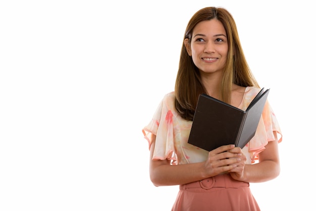 Feliz joven y bella mujer sonriendo mientras sostiene el libro