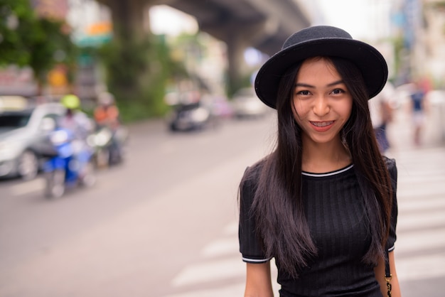 Feliz joven bella mujer turista asiática en las calles de la ciudad