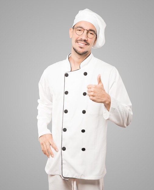 Feliz joven chef gesticulando que todo está bien