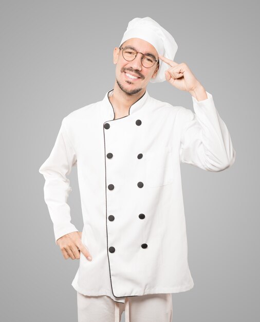 Feliz joven chef haciendo un gesto de concentración