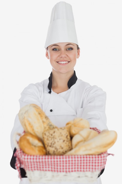 Feliz joven chef mujer con cesta de pan