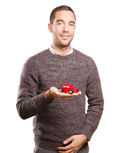 Feliz joven con un coche de juguete
