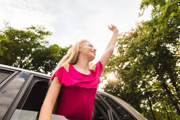 Foto feliz joven en coche mano arriba