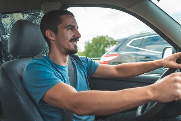 Feliz joven conduciendo un coche bailando y cantando el concepto de transporte y vehículo de viaje divertido