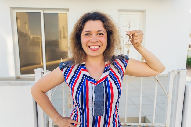 Foto feliz joven delante de casa nueva con llaves de casa nueva