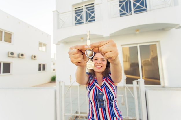 Foto feliz joven delante de casa nueva con llaves de casa nueva