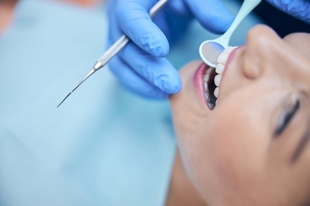 Feliz joven con los dientes tratados en la clínica