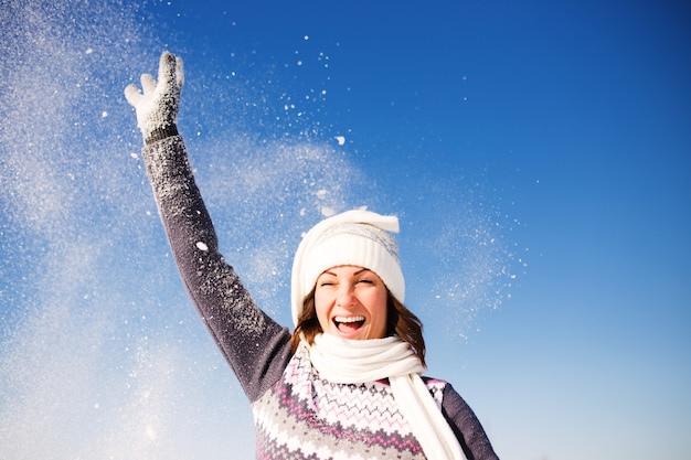 Foto feliz joven diviértete y disfruta de la nieve fresca en el hermoso día de invierno