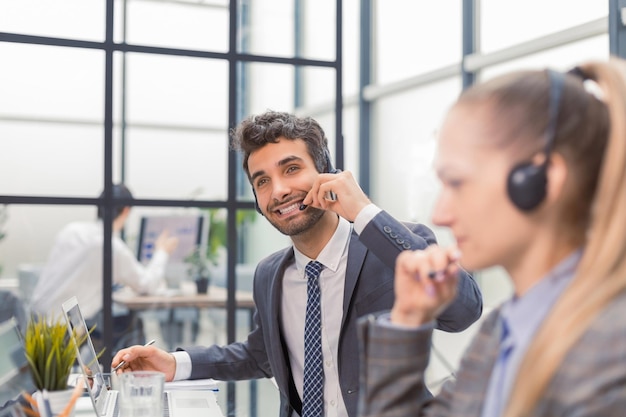 Feliz joven ejecutivo de atención al cliente trabajando en la oficina