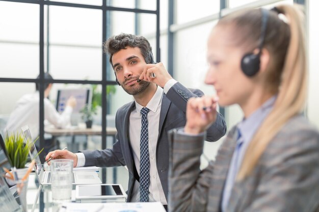 Feliz joven ejecutivo de atención al cliente trabajando en la oficina