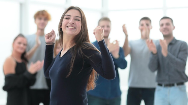 Feliz joven empresaria parada frente al equipo de negocios