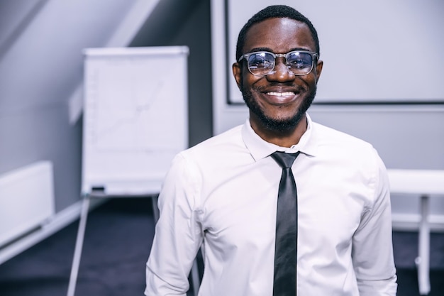 Feliz joven empresario afroamericano en traje formal con gafas