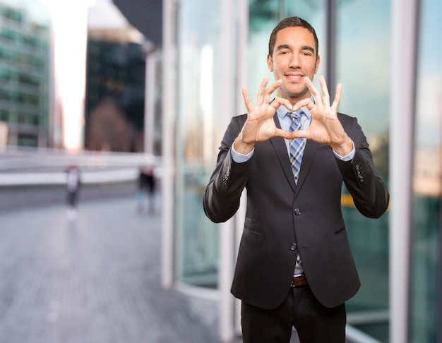 Feliz joven empresario con un gesto de amor