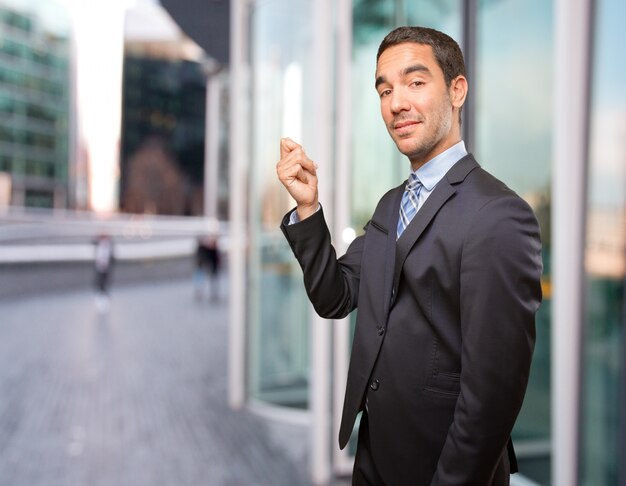 Feliz joven empresario haciendo un gesto de dinero