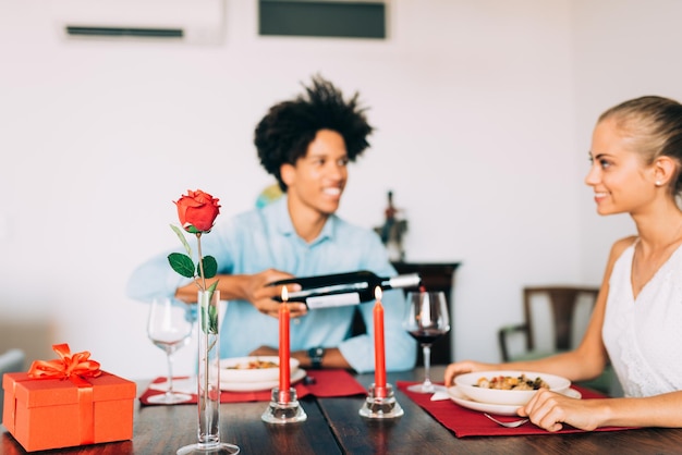 Feliz joven enamorado pareja interracial cenando románticamente en