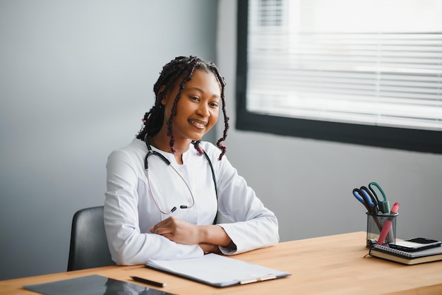 Feliz joven enfermera africana trabajando en la oficina