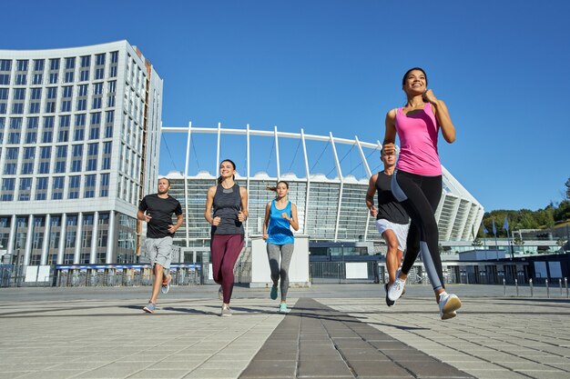 Feliz joven equipo racial mixto corriendo durante el entrenamiento