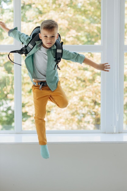 Feliz joven escolar con mochila saltando