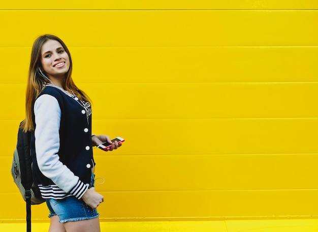 Foto feliz joven escuchando música en auriculares