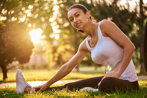 Feliz joven estiramiento antes de correr al aire libre