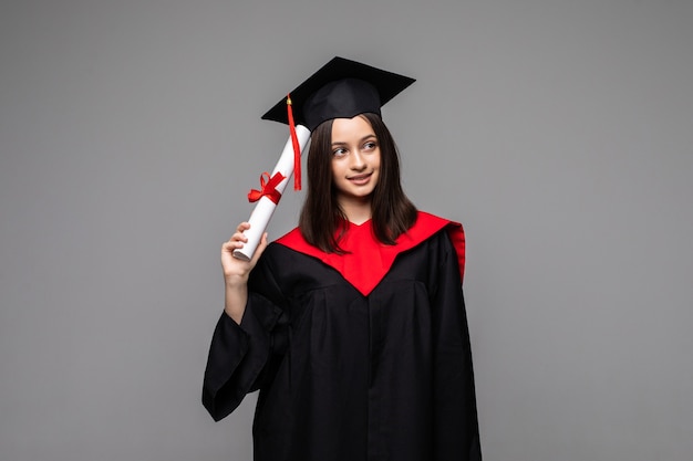 Feliz joven estudiante con diploma en gris