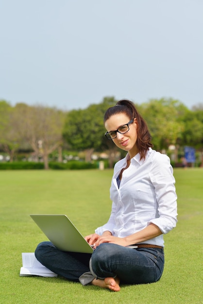 feliz joven estudiante mujer con laptop en el estudio del parque de la ciudad